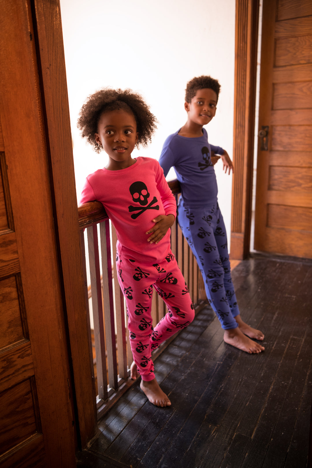 Two kids in blue and pink skull pajamas