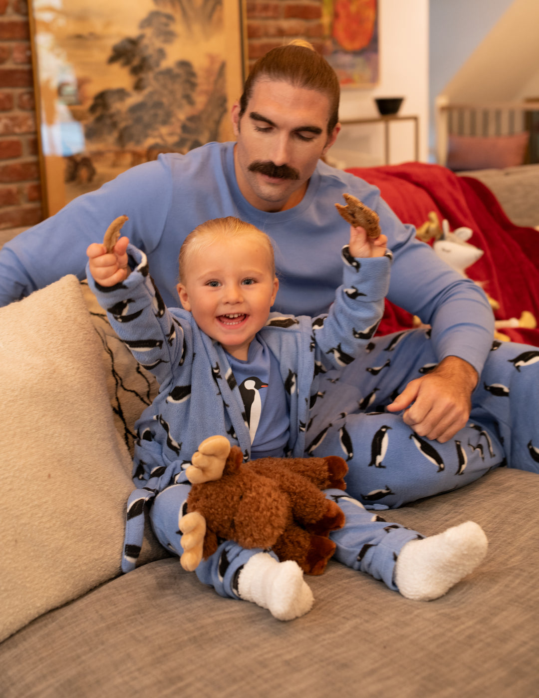 dather and son wearing matching fleece penguin pajamas